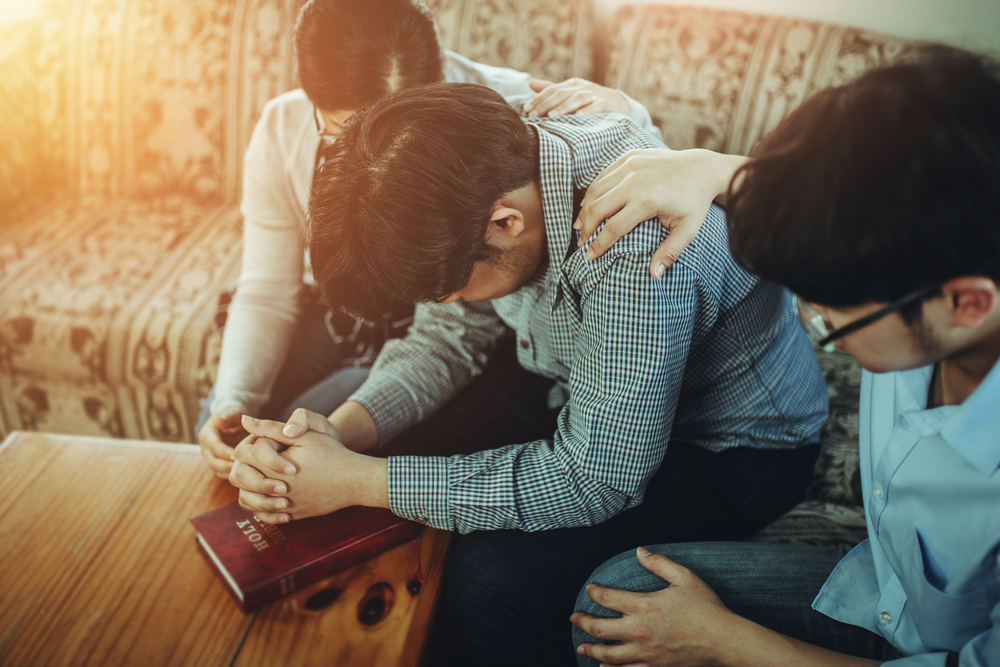 A,Christian,Young,Man,Praying,For,His,Friends,While,Sitting