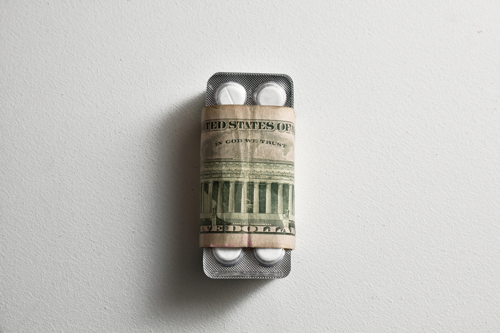 New,Health,Care,Policy.,Pills,Rolled,In,Us,Dollar,Banknote,