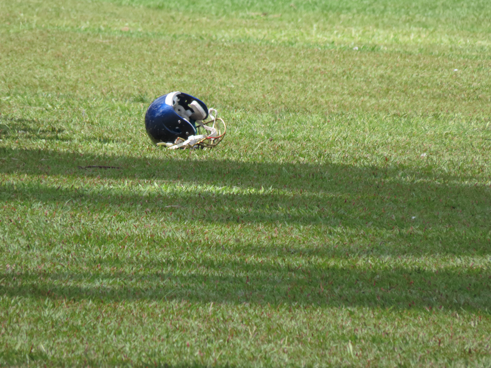 American,Football,Helmet,Over,Grass