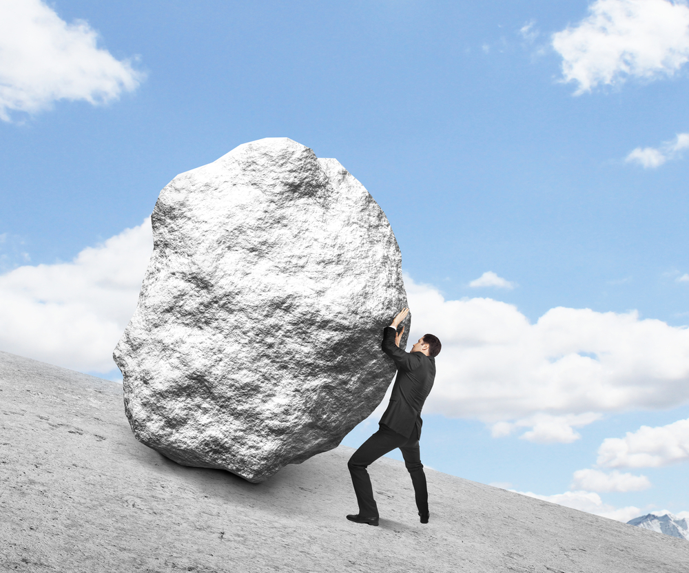 Businessman,Pushing,Stone,Up,Hill,And,Sky