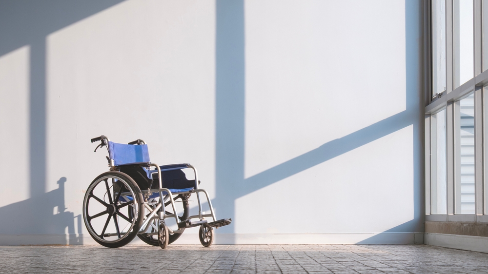 Empty,Wheelchair,On,Cobblestone,Tile,Floor,With,Light,And,Shadow